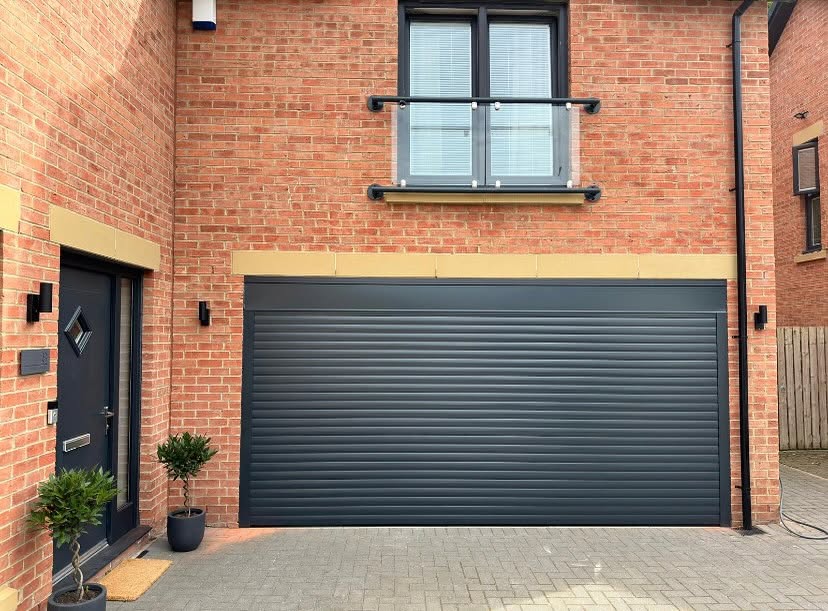 Anthracite grey double roller garage door on a modern brick home