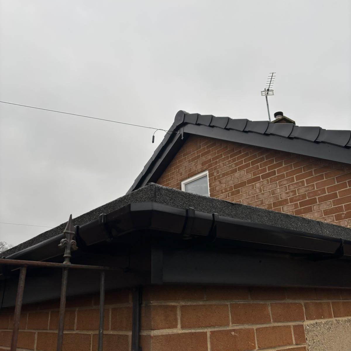Black fascias and guttering replacement on a brick gable
